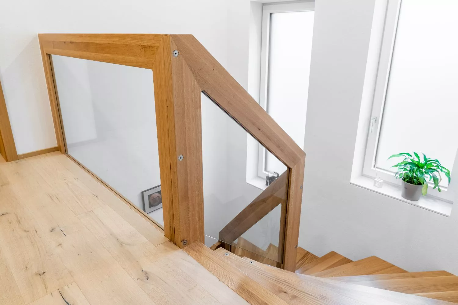 Vorraum mit 2 Großen Fenstern im Vordergrund ein Brüstungsgeländer aus Holz und Glas