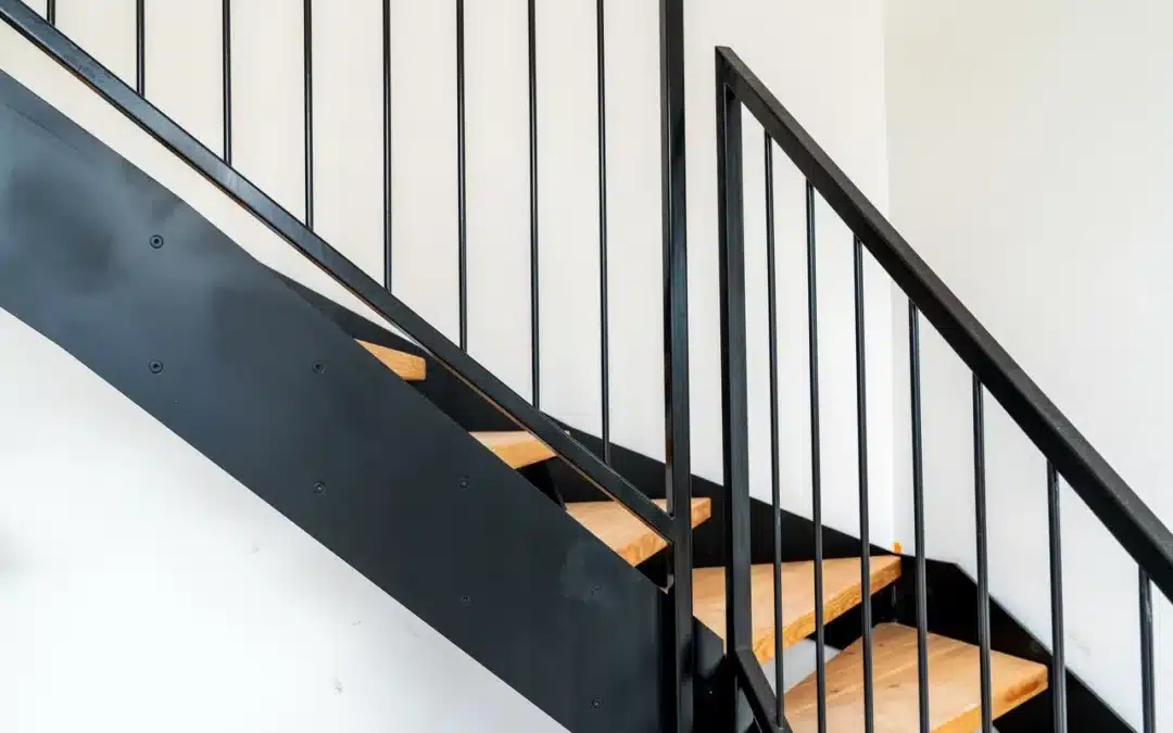 Blick auf eine Stiege mit schwarzem Geländer aus Stahl